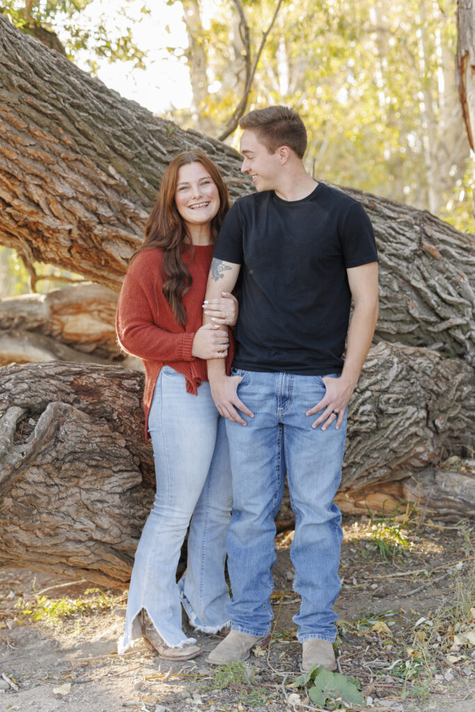 A couple poses under a large tree in Montana