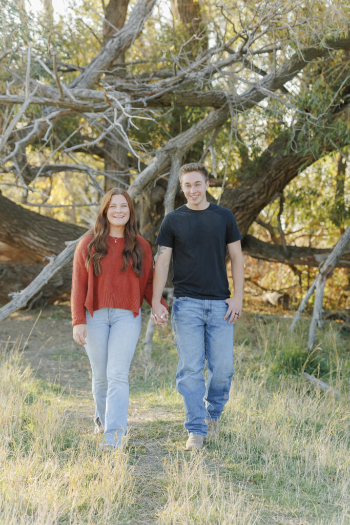 A couple walks away from a large tree in Montana