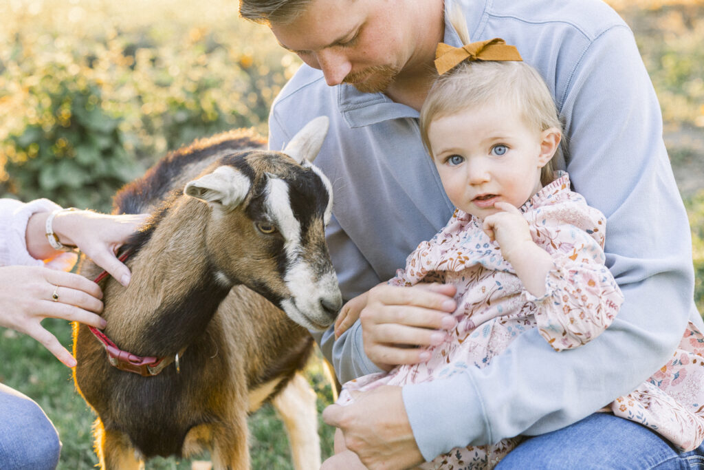 dad holds daughter on goat farm in Montana