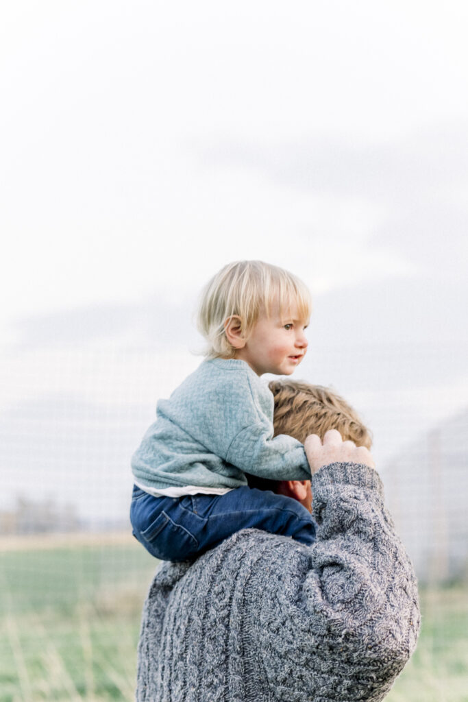 toddler gets a ride on dad's shoulders