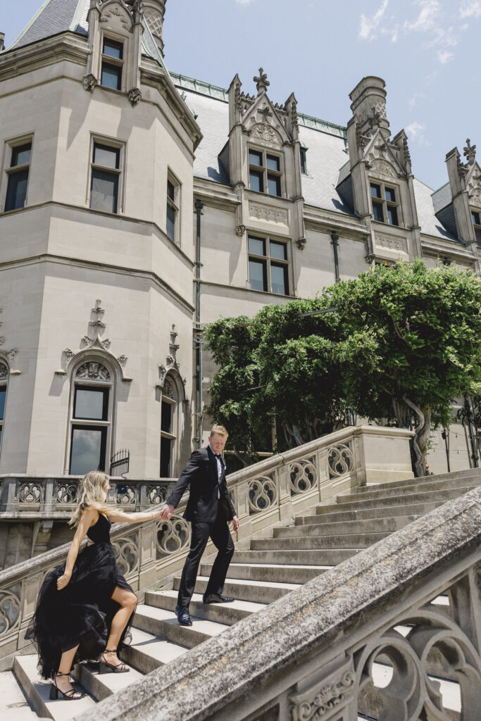 Black tie Engagement photo session at the Biltmore with black tulle dress and black tux going up stairs