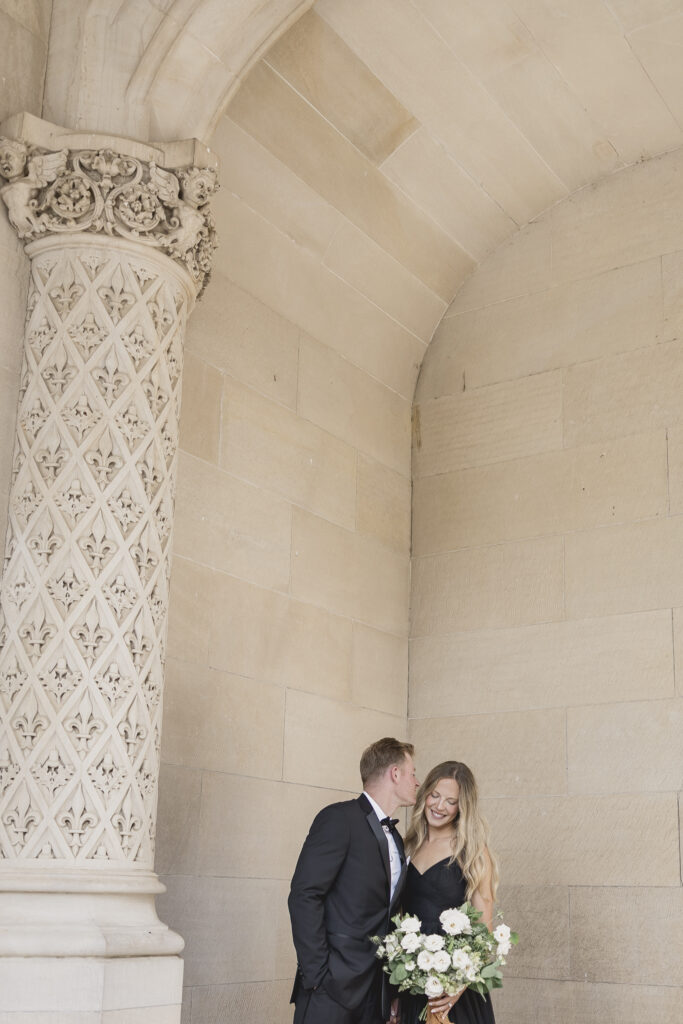 Engaged couple in black dress and black tux with white bouquet at the Biltmore Estate