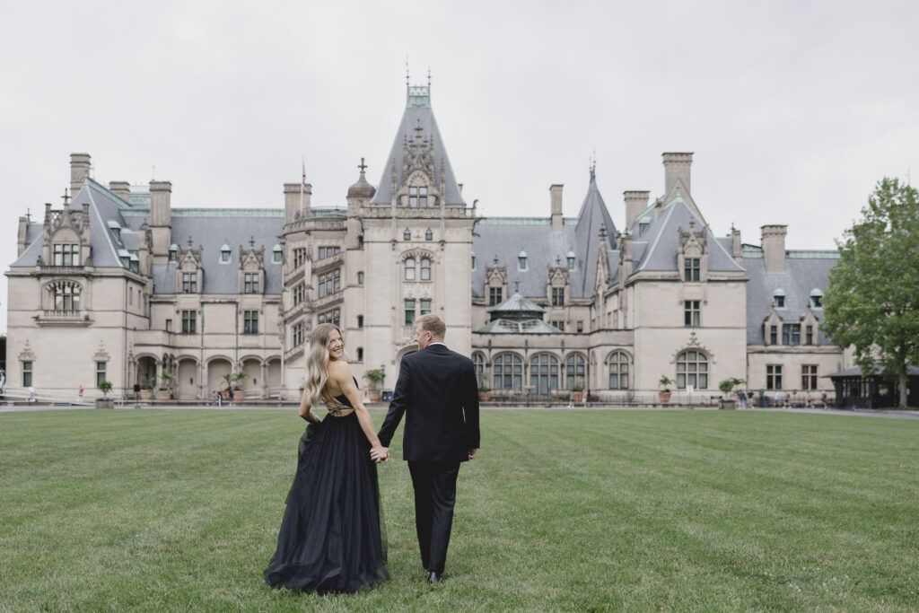 Engaged couple holding hands in front of the Biltmore Estate