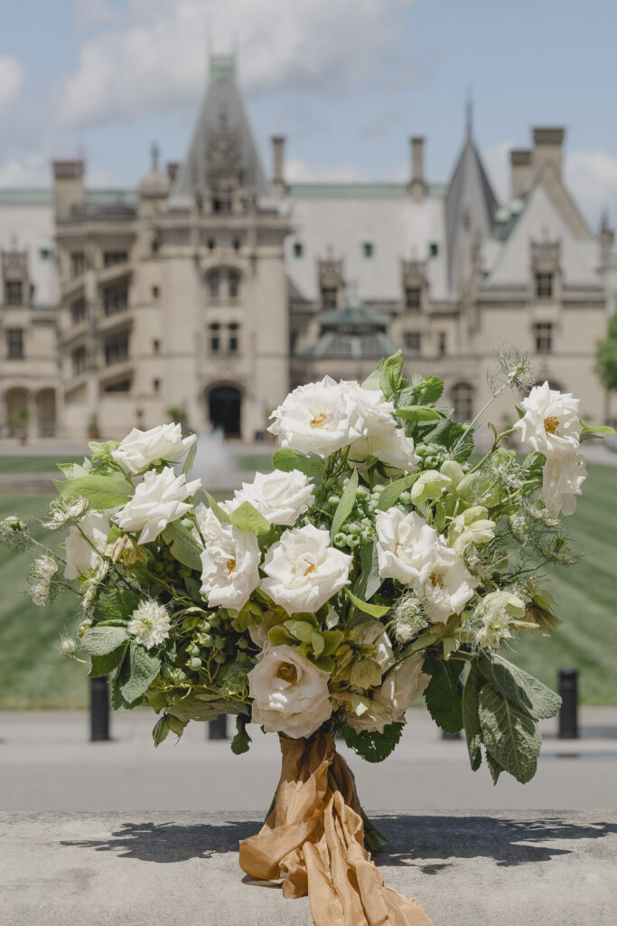 Black tie Engagement photo session at the Biltmore with black tulle dress. Rachel Deneroy Designs white floral bouquet using blueberries and mint at the Biltmore Estate.