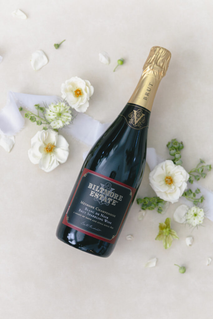 Engagement photos at the Biltmore with a champagne toast. Biltmore estate champagne bottle flat lay design